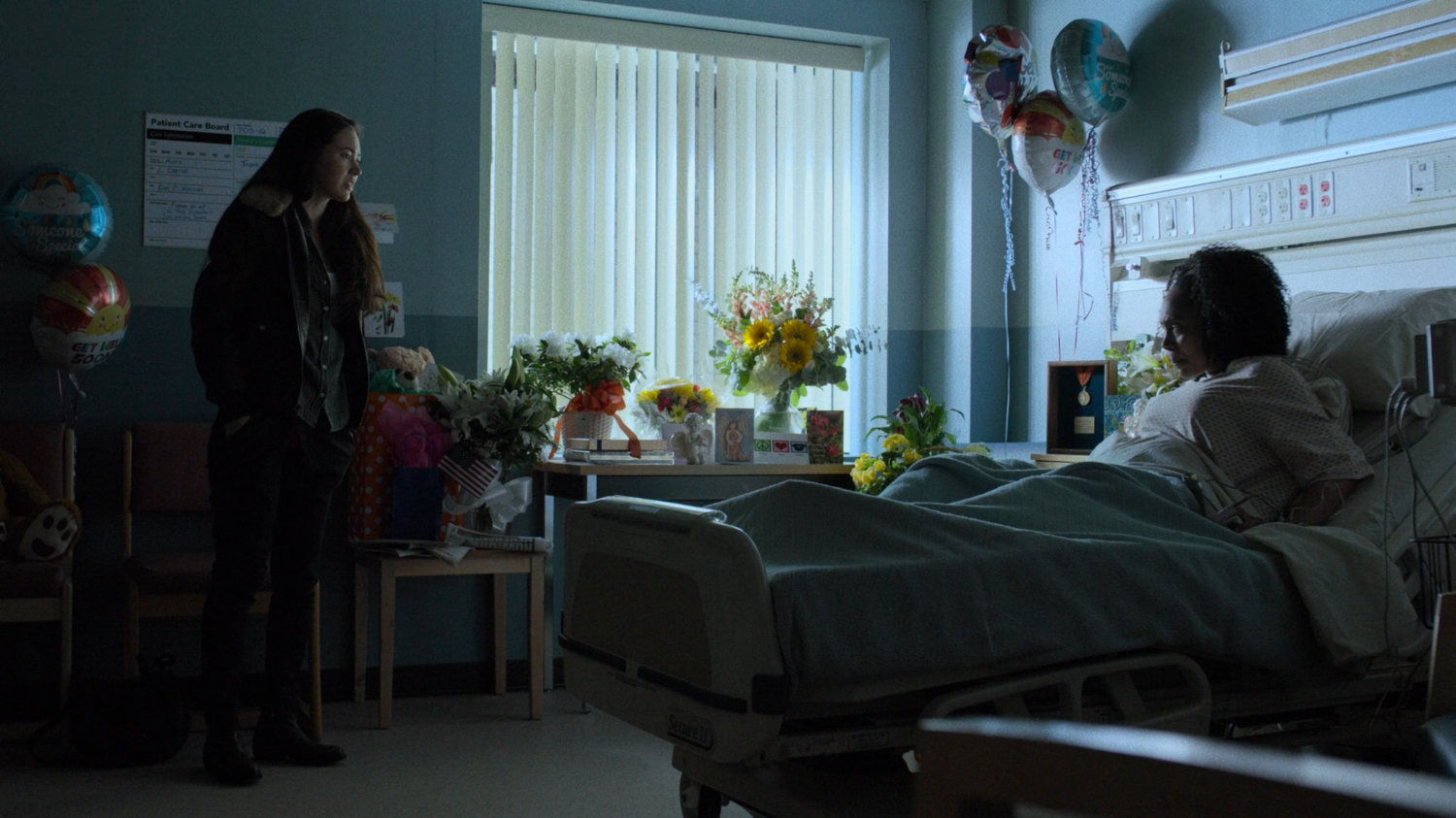 Colleen talking to Misty in a hospital room.