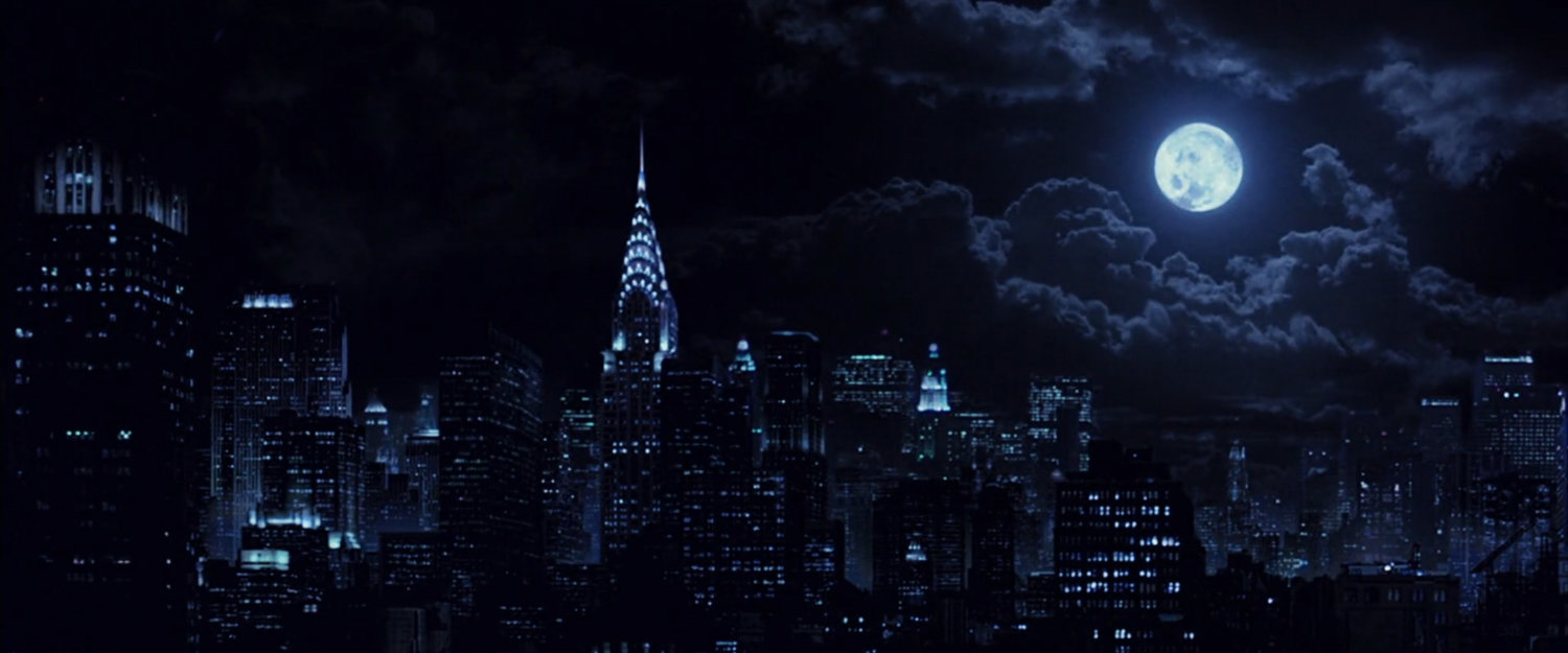 New York City skyline at night with full moon.