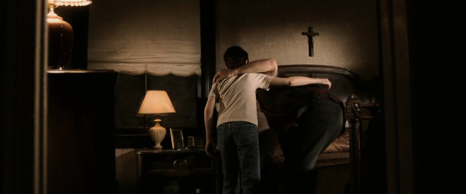 Young Matt helps his father into bed in their apartment.
