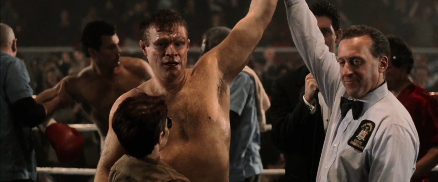 Referee holds up Jack Murdock's hand after a boxing match at the Olympic Auditorium.