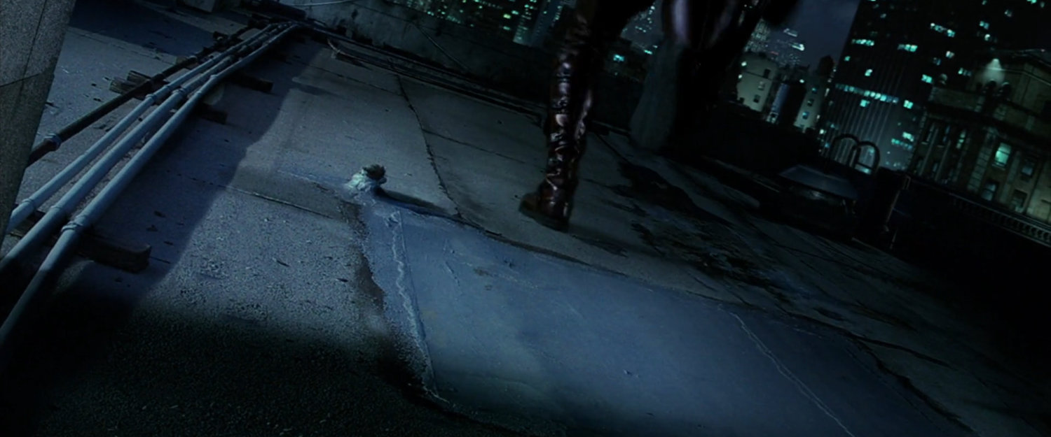 Daredevil running across rooftop at night.