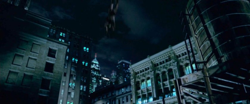 Daredevil swinging on a rooftop clothesline at night.