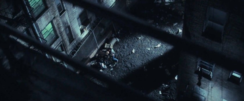 View from rooftop of man beating someone up in an alley.