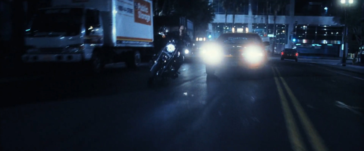 Bullseye riding motorcycle through traffic.