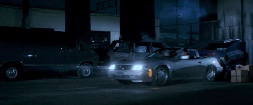 Mackenzie's car crashing into dumpster outside topless bar.