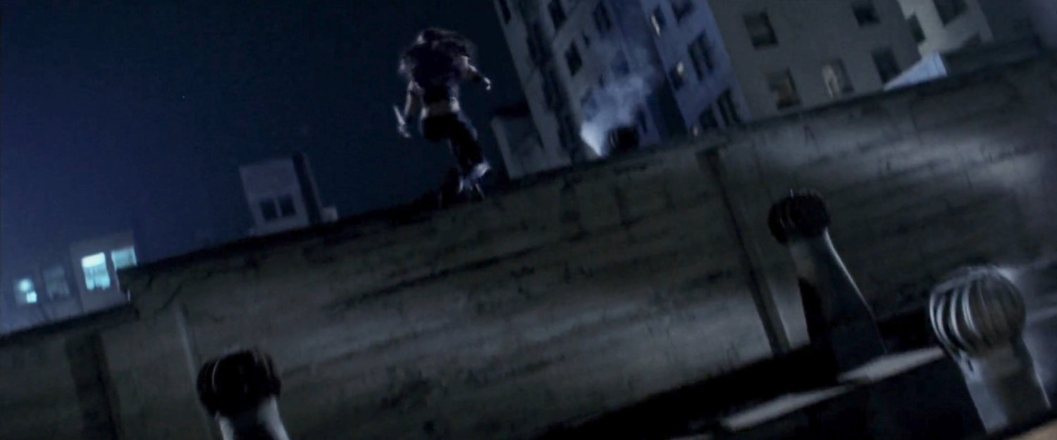 Elektra jumping over a ledge on rooftop at night.