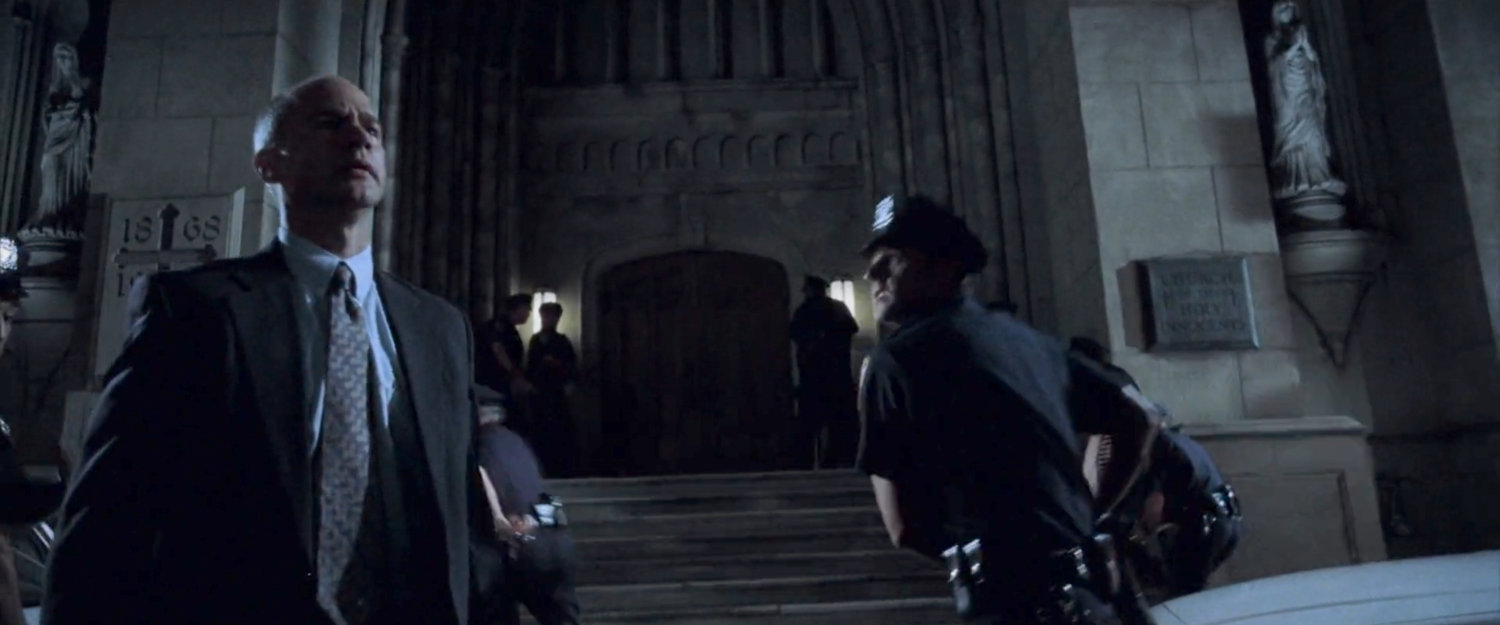 Detective Manolis and an officer outside the Church of the Holy Innocents.