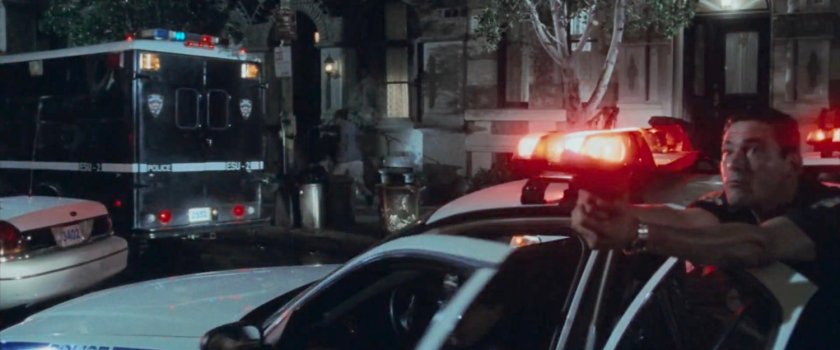 Police officer drawing his gun outside the Church of the Holy Innocents.