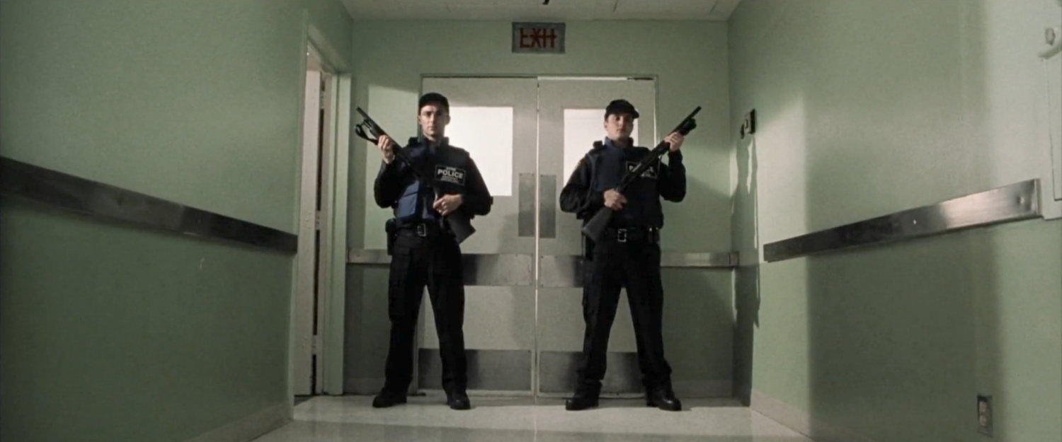 Armed officers stand watch outside doors in hospital.