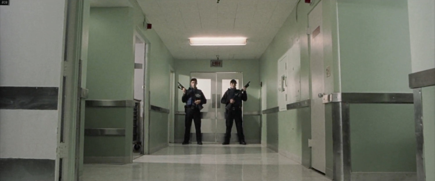Armed officers stand watch outside doors in hospital.