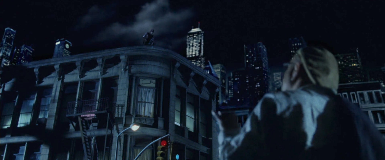 Ben Urich looking up at Daredevil on rooftop across street.