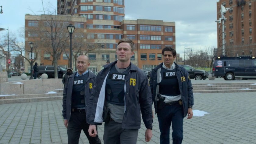 Agents Dex, Nadeem, and Arinori walk across an outdoor pavilion.