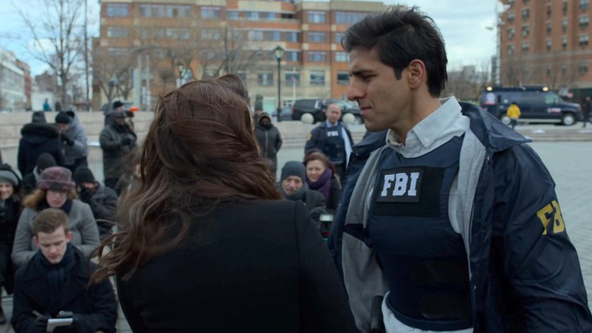 Agent Nadeem speaks quietly at Rosalie Carbone at an outdoor ceremony.