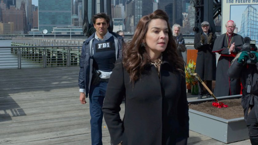 Agent Nadeem leads Rosalie Carbone away from an outdoor ceremony.