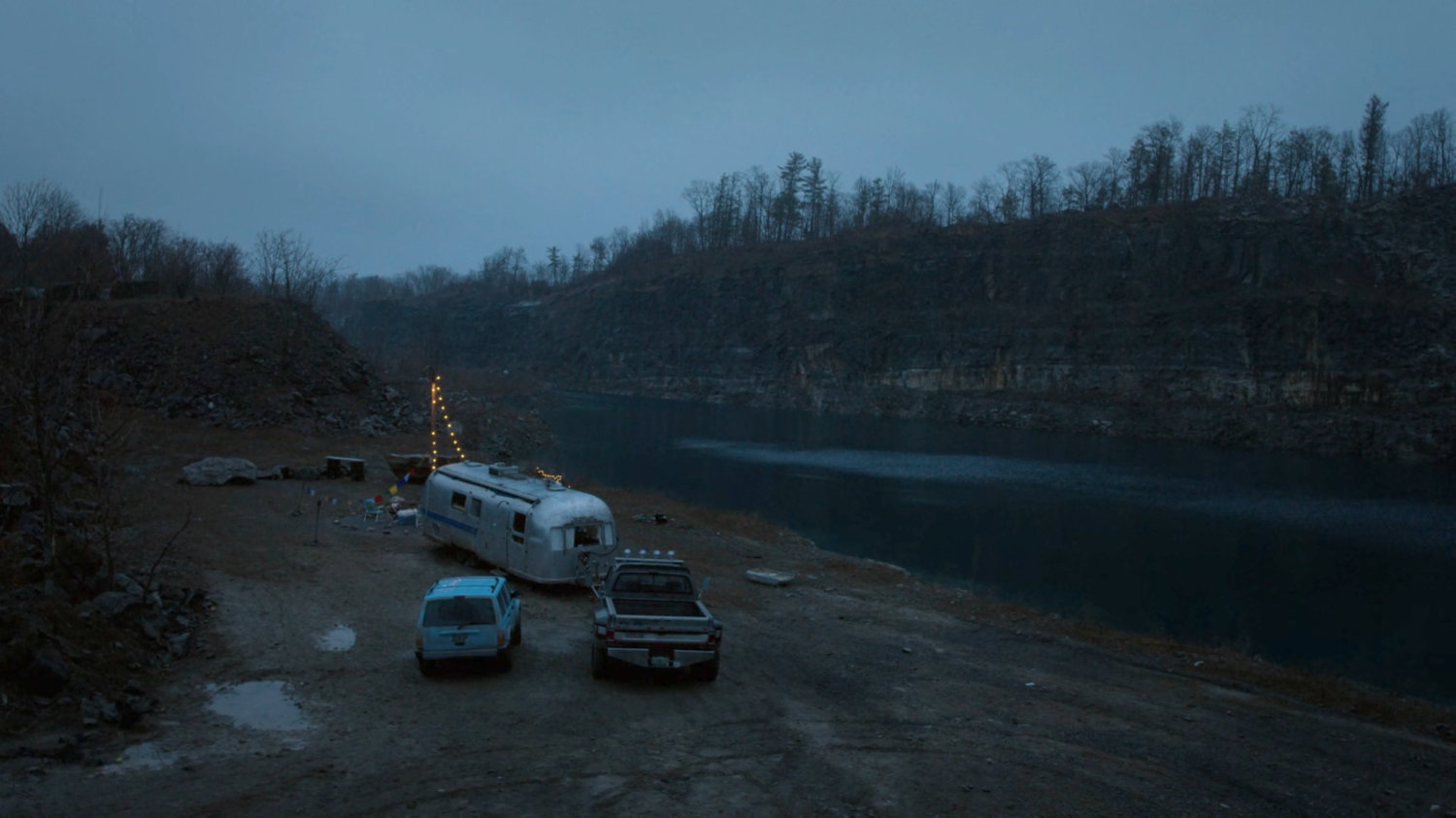 Two pickups parked outside a silver trailer at a quarry in Vermont.