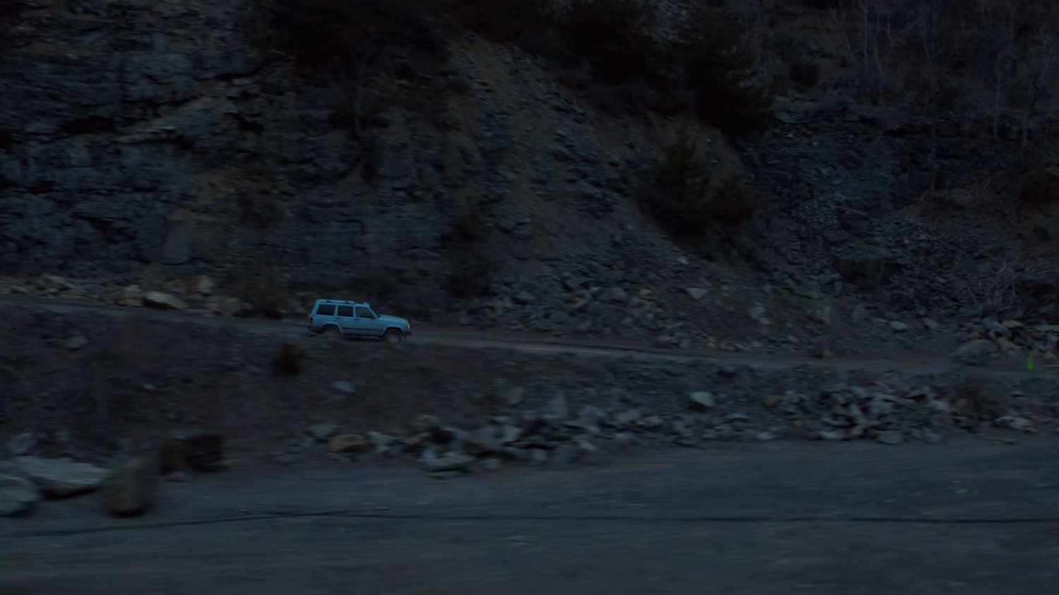 Karen's blue truck driving on a dirt road at a quarry in Vermont.