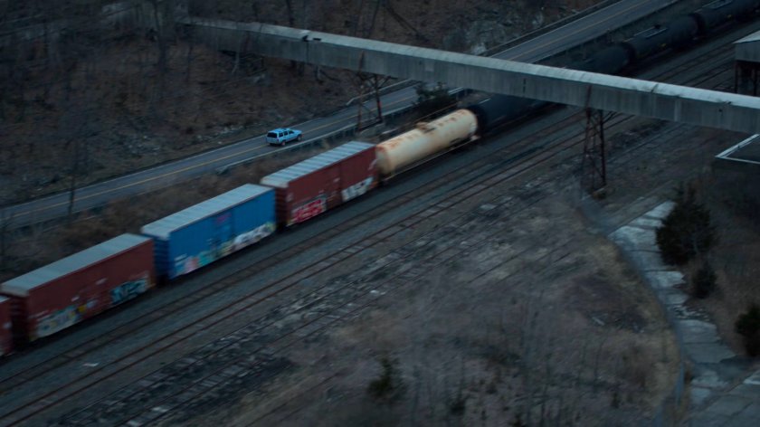 Karen's blue truck driving on a road along side a train track in Vermont.