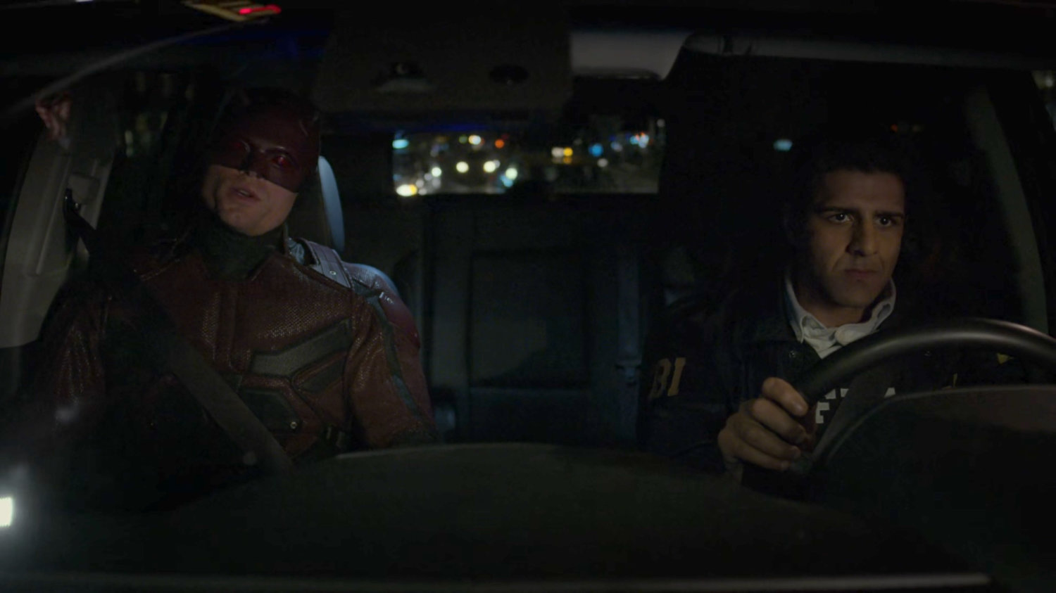 Dex, dressed as Daredevil and Nadeem in car on a dark New York street.
