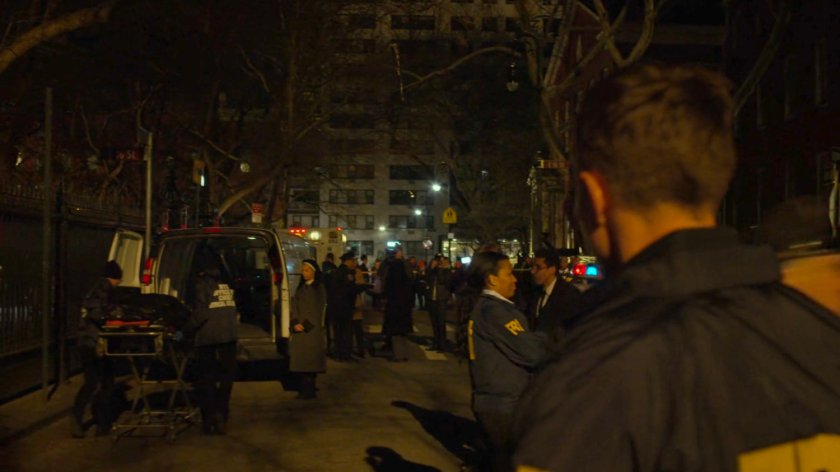 Dex watches Maggie by an ambulance outside Clinton Church.