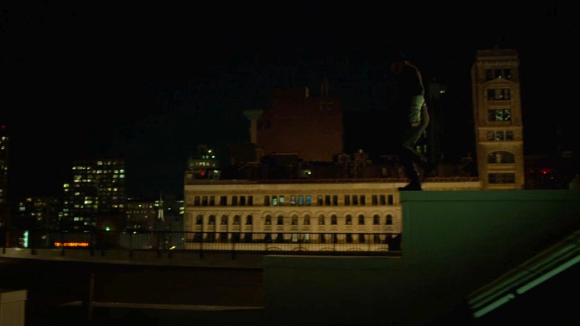 Matt on a ledge on a rooftop.