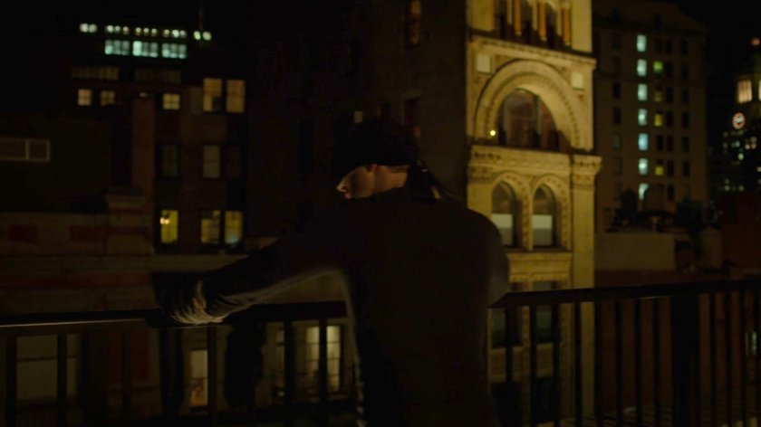 Matt leaning on the railing of a rooftop.