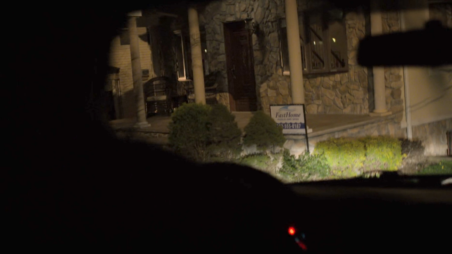 Headlights illuminate the front porch of the Nadeem house.