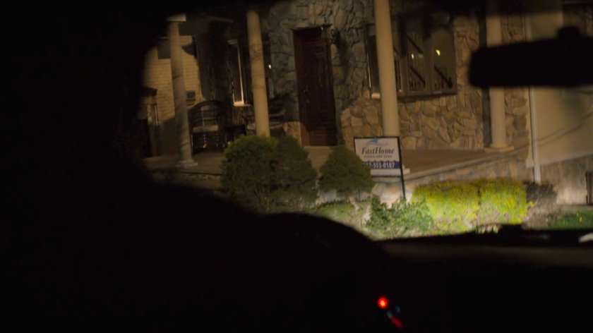 Headlights illuminate the front porch of the Nadeem house.
