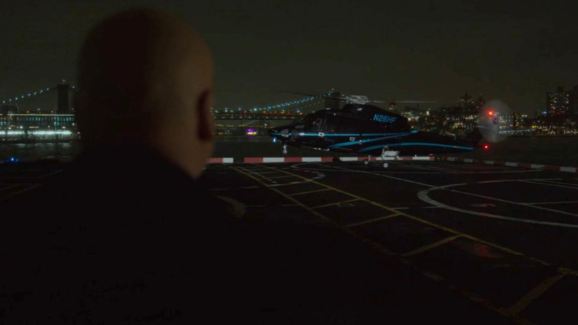 Fisk watching helicopter landing on platform at night.
