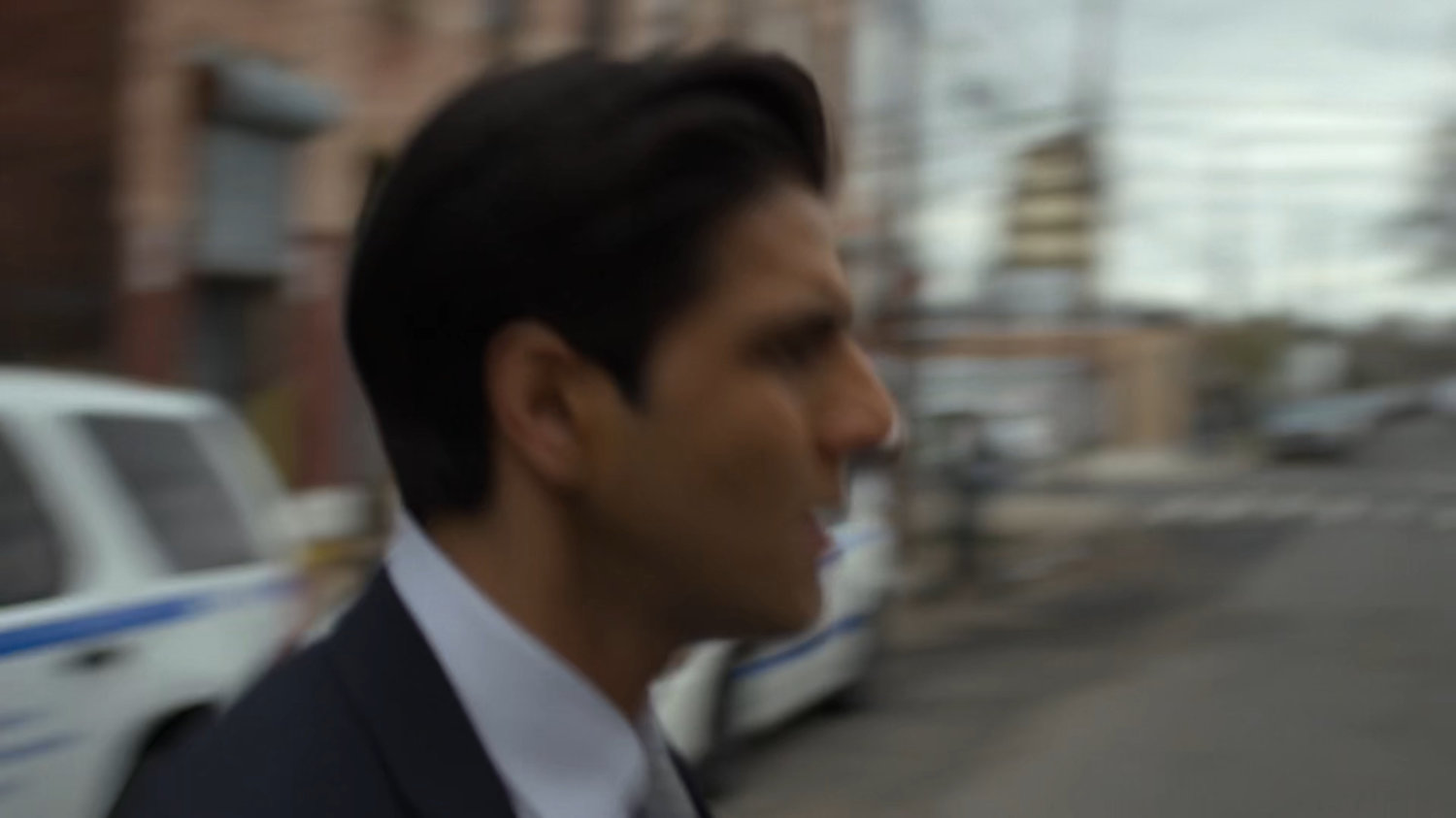 Blurry image of Ray crossing street.