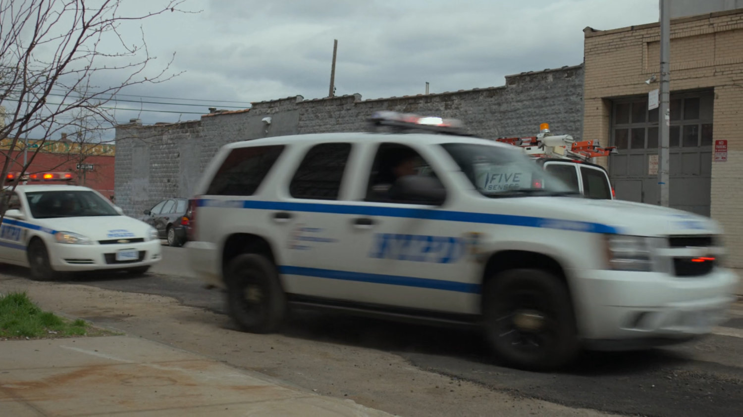 NYPD vehicles speed away from Fogwell's Gym.