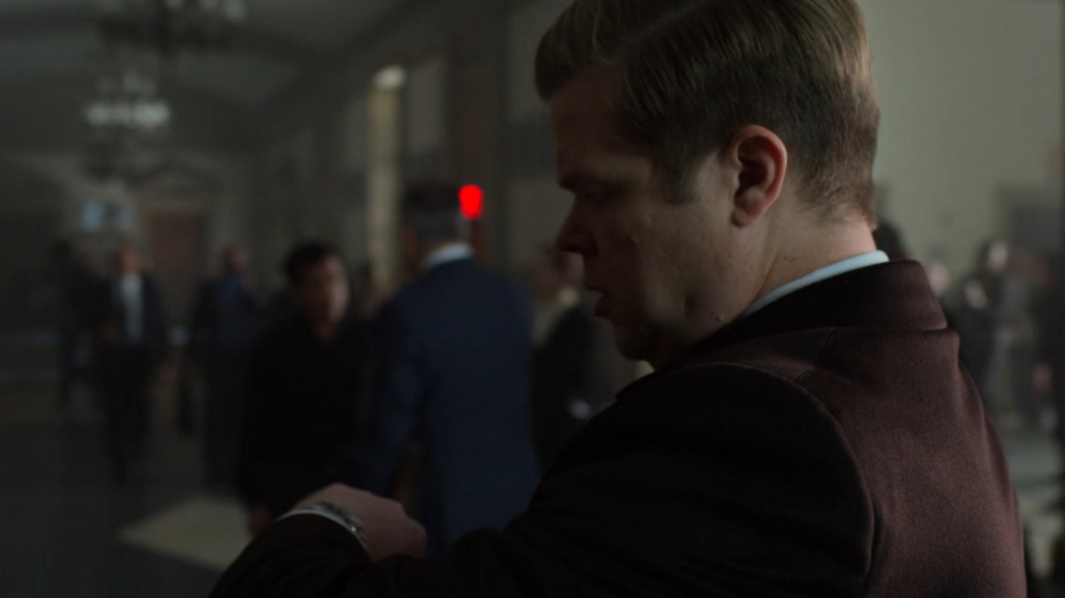 Foggy looking at his watch in a courthouse.