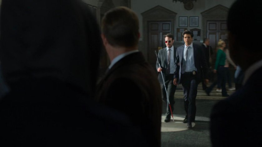 Matt and Nadeem walking towards Foggy in a courthouse.