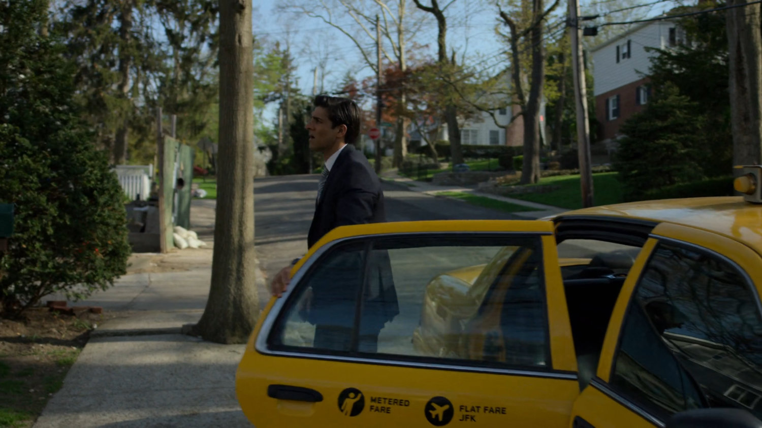 Ray exiting cab outside his house.