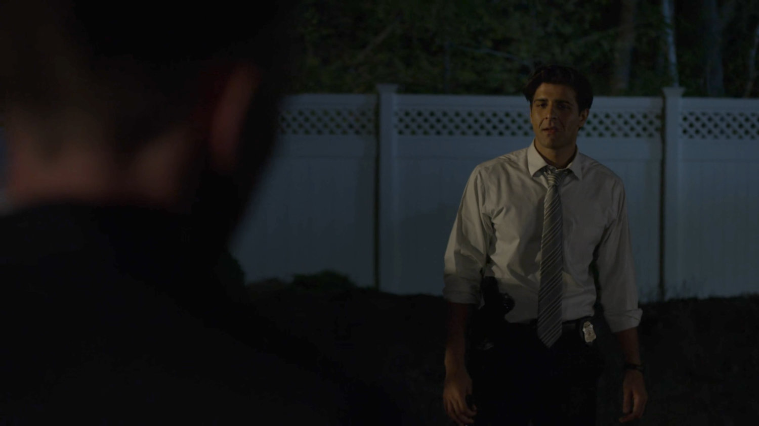 Dex holds a gun on Ray in the Nadeem backyard.