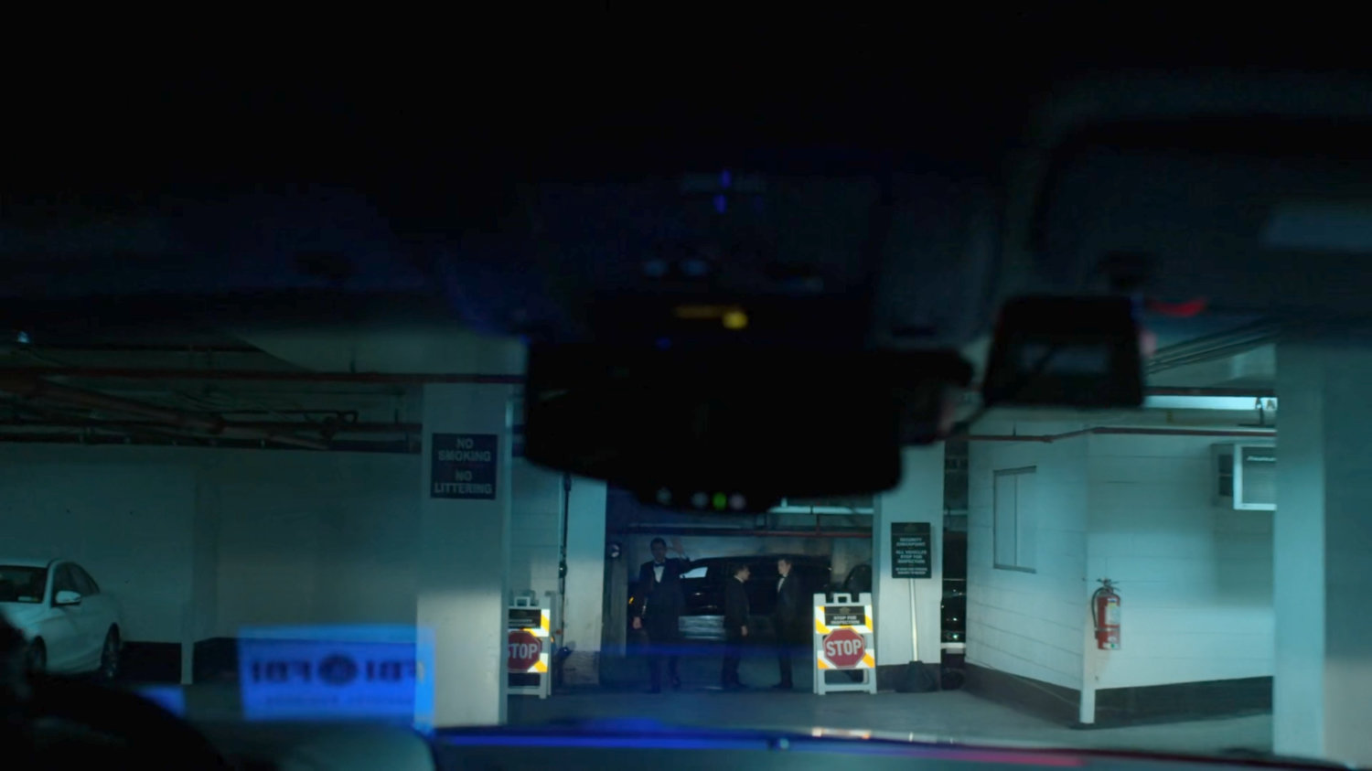 POV inside vehicle at a security checkpoint in parking garage of Presidential Hotel.