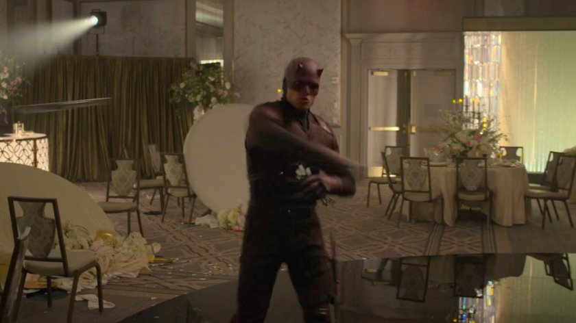 Dex, dressed as Daredevil, throws cuttlery at FBI Agents at the wedding reception in the Presidential Hotel ballroom.