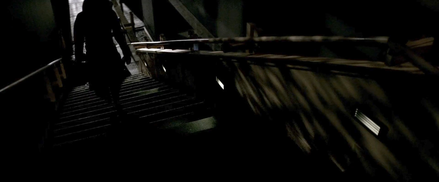 Shadowy figure walking up stairs in Demarco's residence.