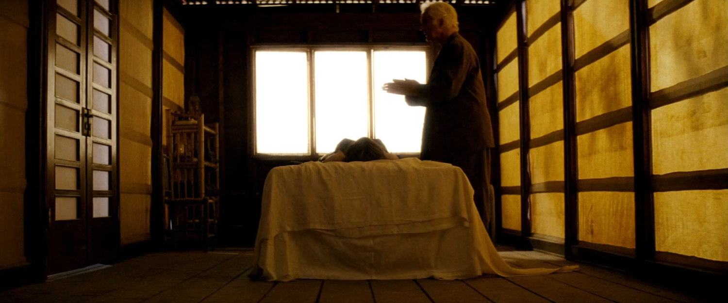 Stick standing above injured Elektra in Chaste camp room.