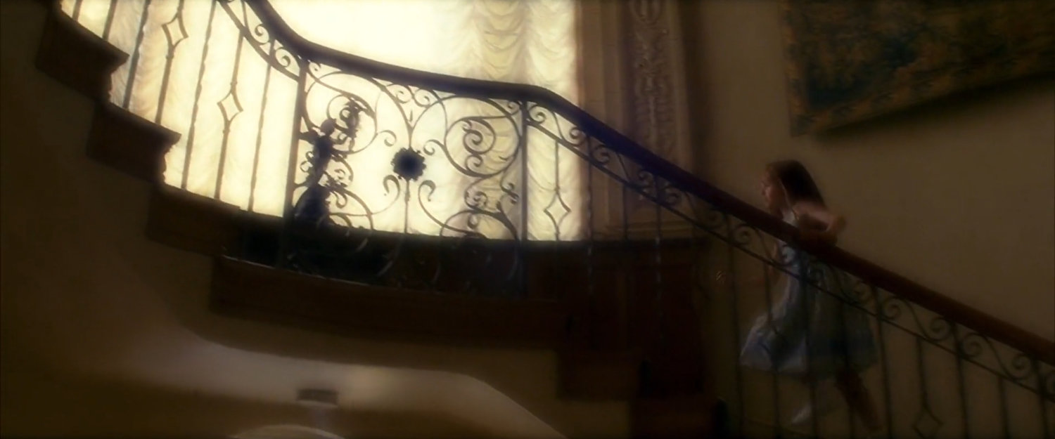 Young Elektra on the stairs of the Natchios mansion.