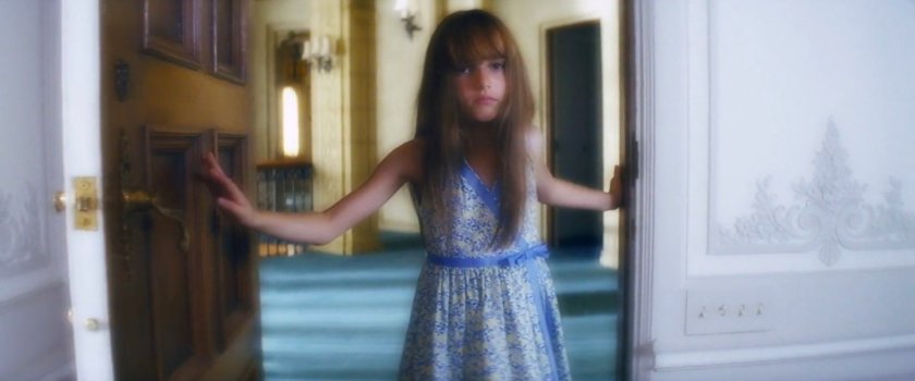 Young Elektra looking into her mother's room in the Natchios mansion.