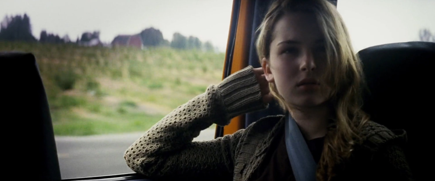 Abby inside a pickup truck on a rural road.