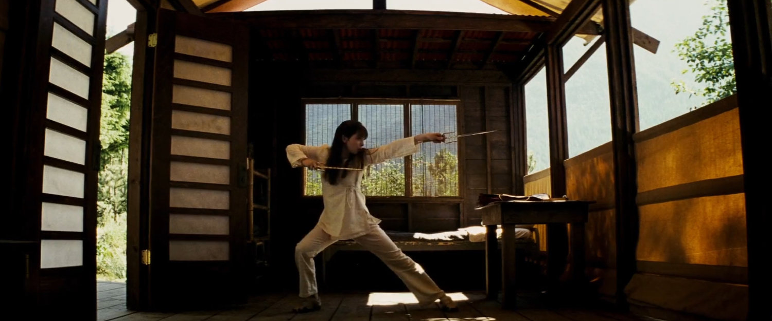 Abby practices with sais inside small cabin at Chaste camp.