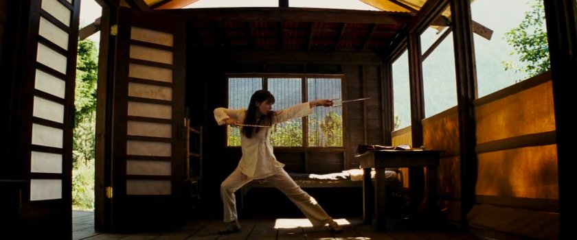 Abby practices with sais inside small cabin at Chaste camp.