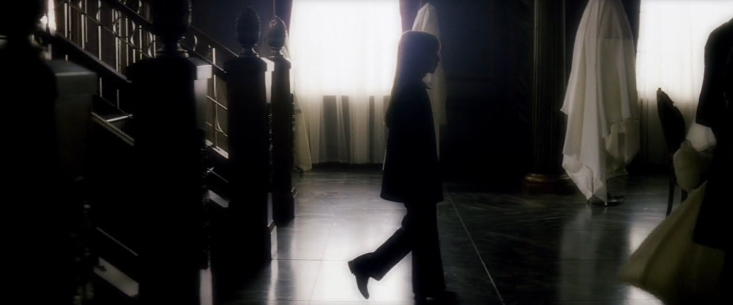 Elektra in main front room of the Natchios mansion.