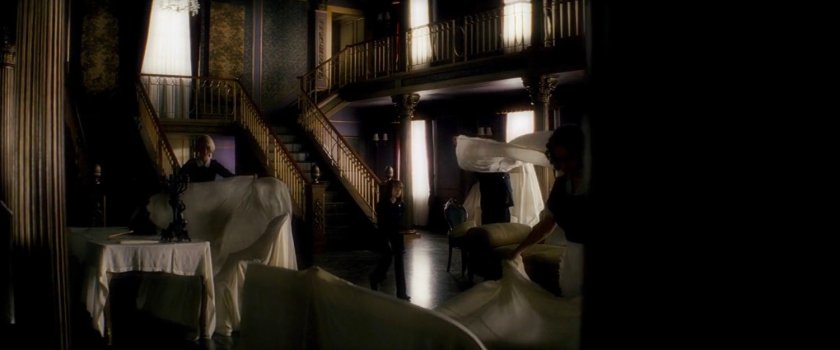 Elektra in main front room of the Natchios mansion.