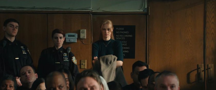 Karen standing at the back of the courtroom.