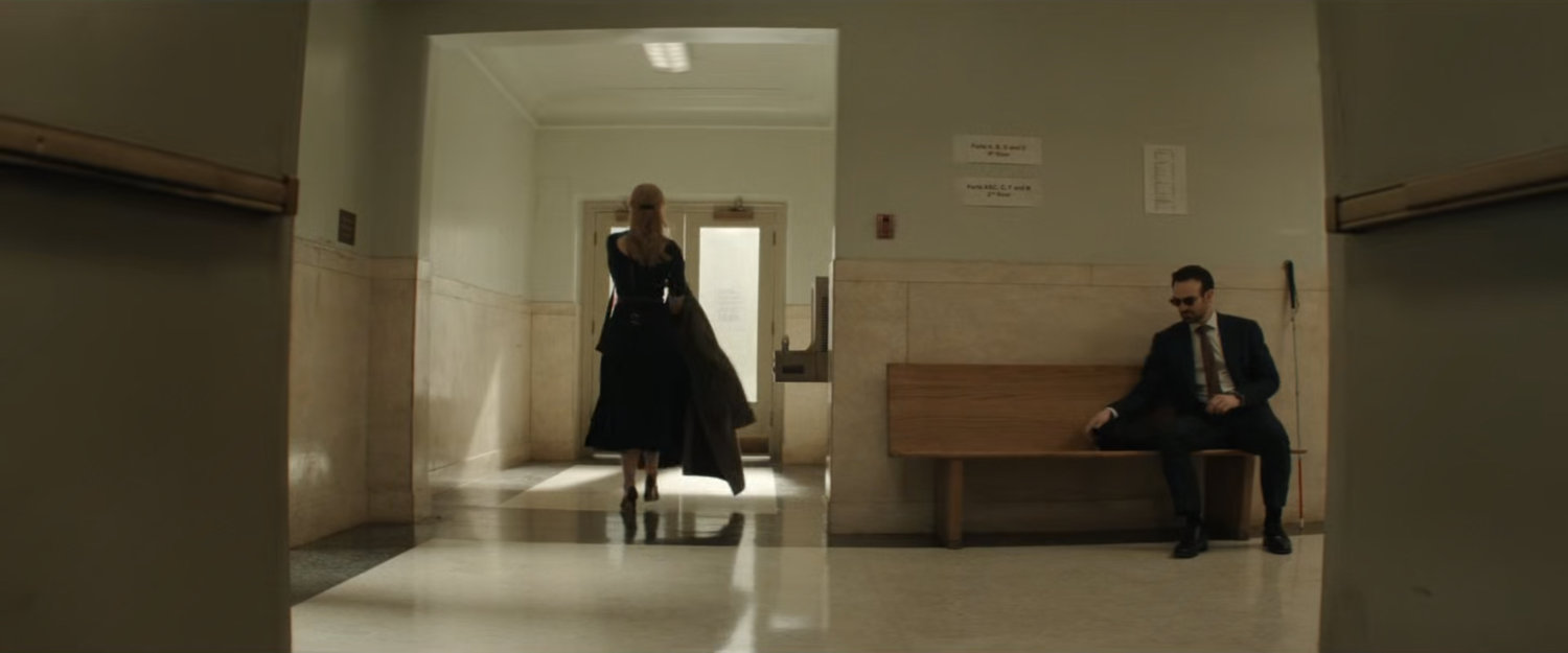 Karen walking away from Matt in the hallway outside the court.