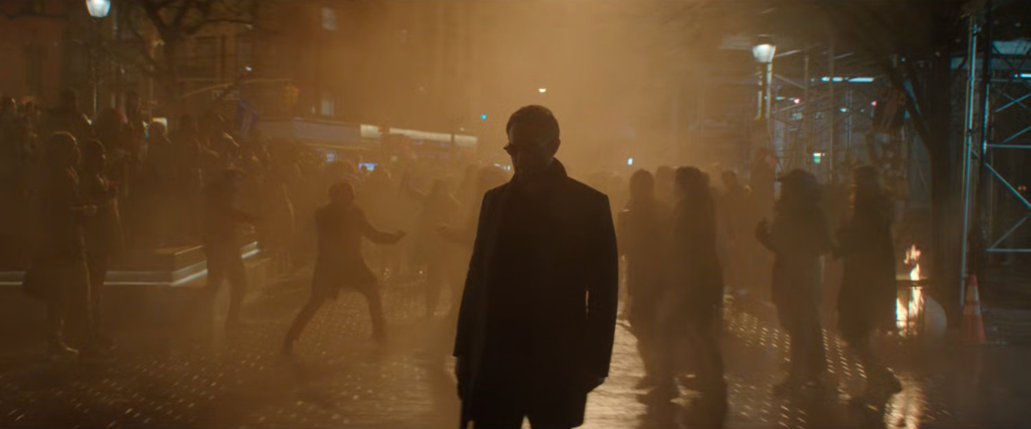 Matt on a smoky street with celebrating pedestrians behind him.