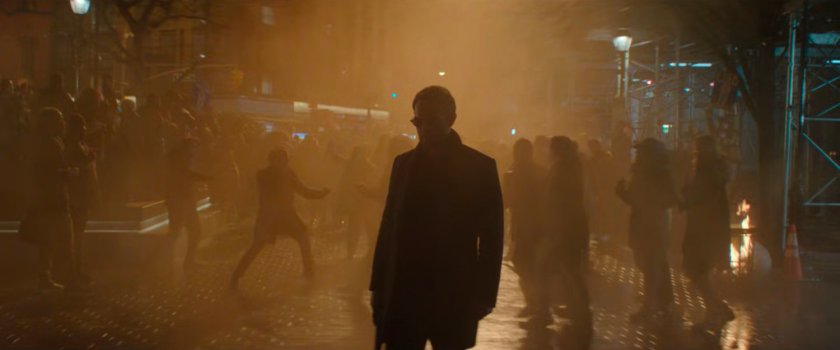 Matt on a smoky street with celebrating pedestrians behind him.