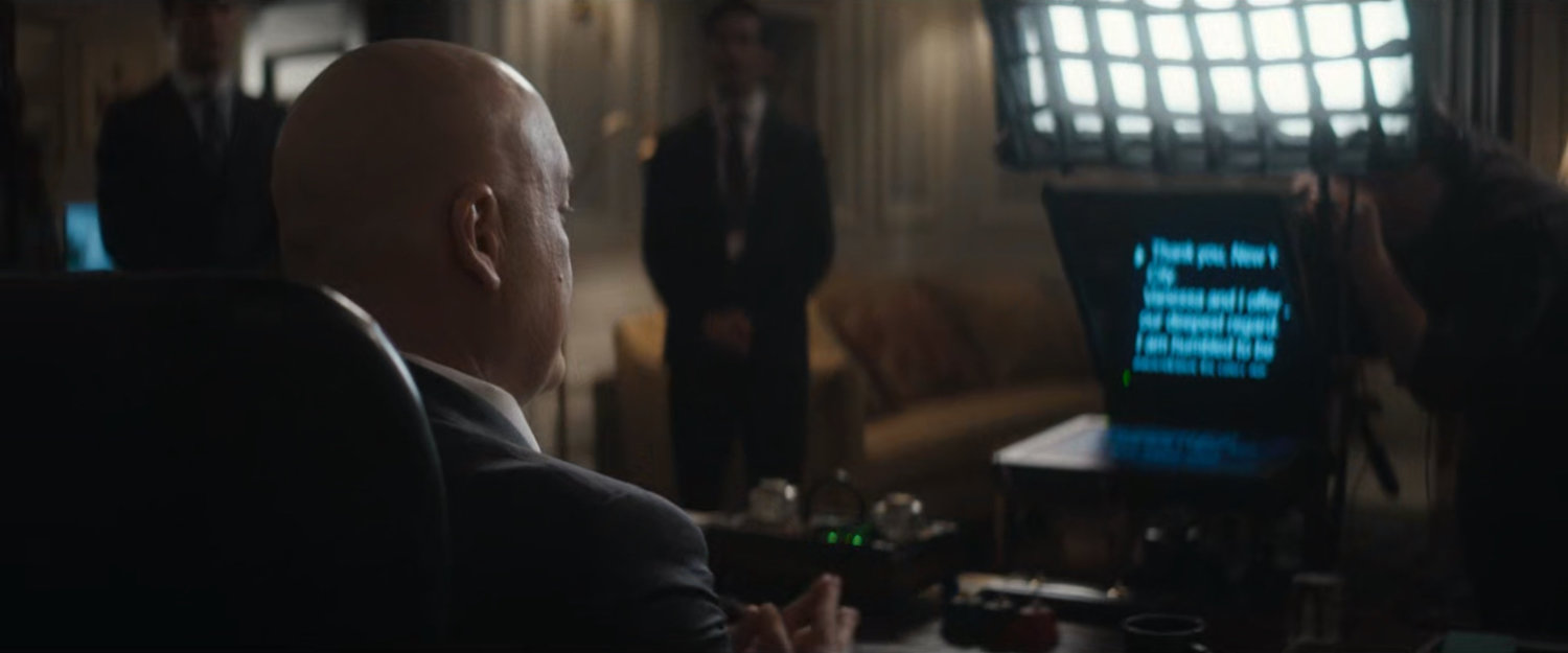 Fisk in the Mayor's office before a teleprompter.